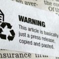 image of a sticker over newsprint: sticker reads "WARNING This article is basically just a press release, copied and pasted."