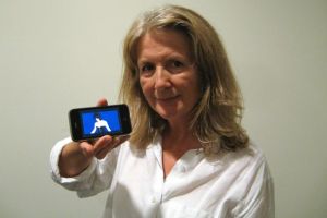 Sally Potter holds out a smartphone showing Jude Law.