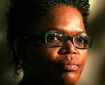 Head portrait of black woman with glasses.