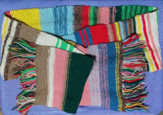 A very old and scraggly woollen scarf, knitted in rows of many colours a la Tom Baker, the 4th Doctor